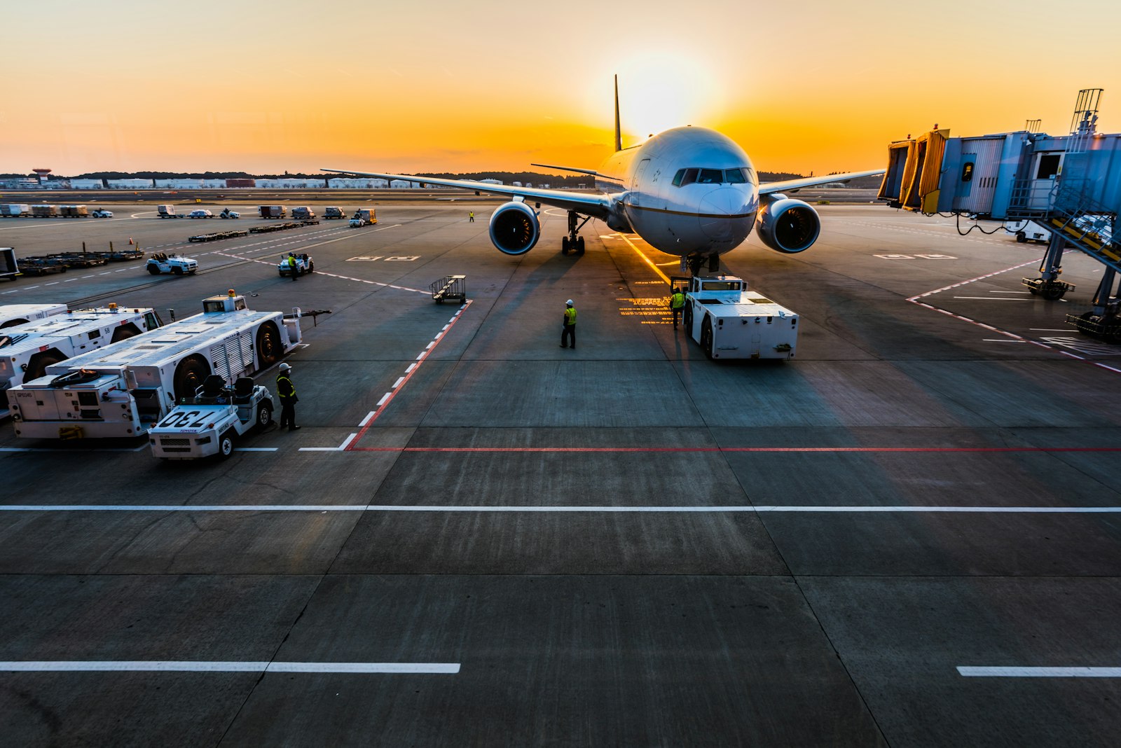 Passenger aircraft at an airport gate at sunset
